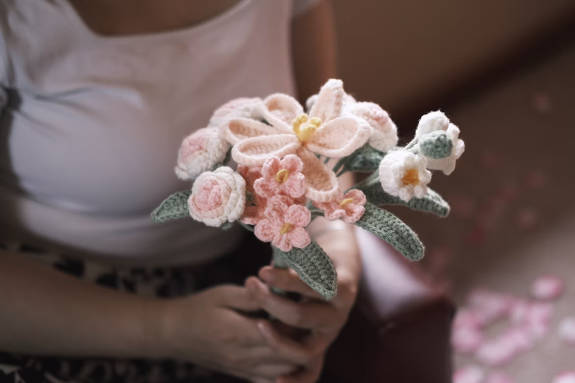 Hands holding a handmade crochet flower bouquet