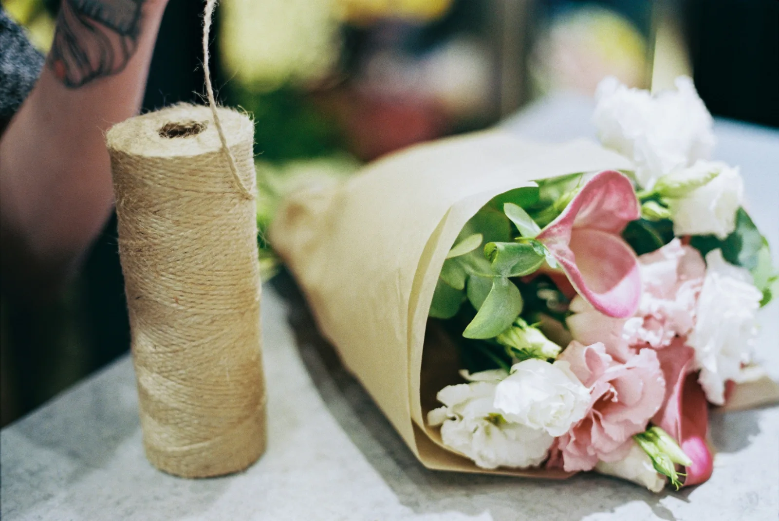 Hands wrapping a bespoke bouquet at The Floral Muse, Leeds